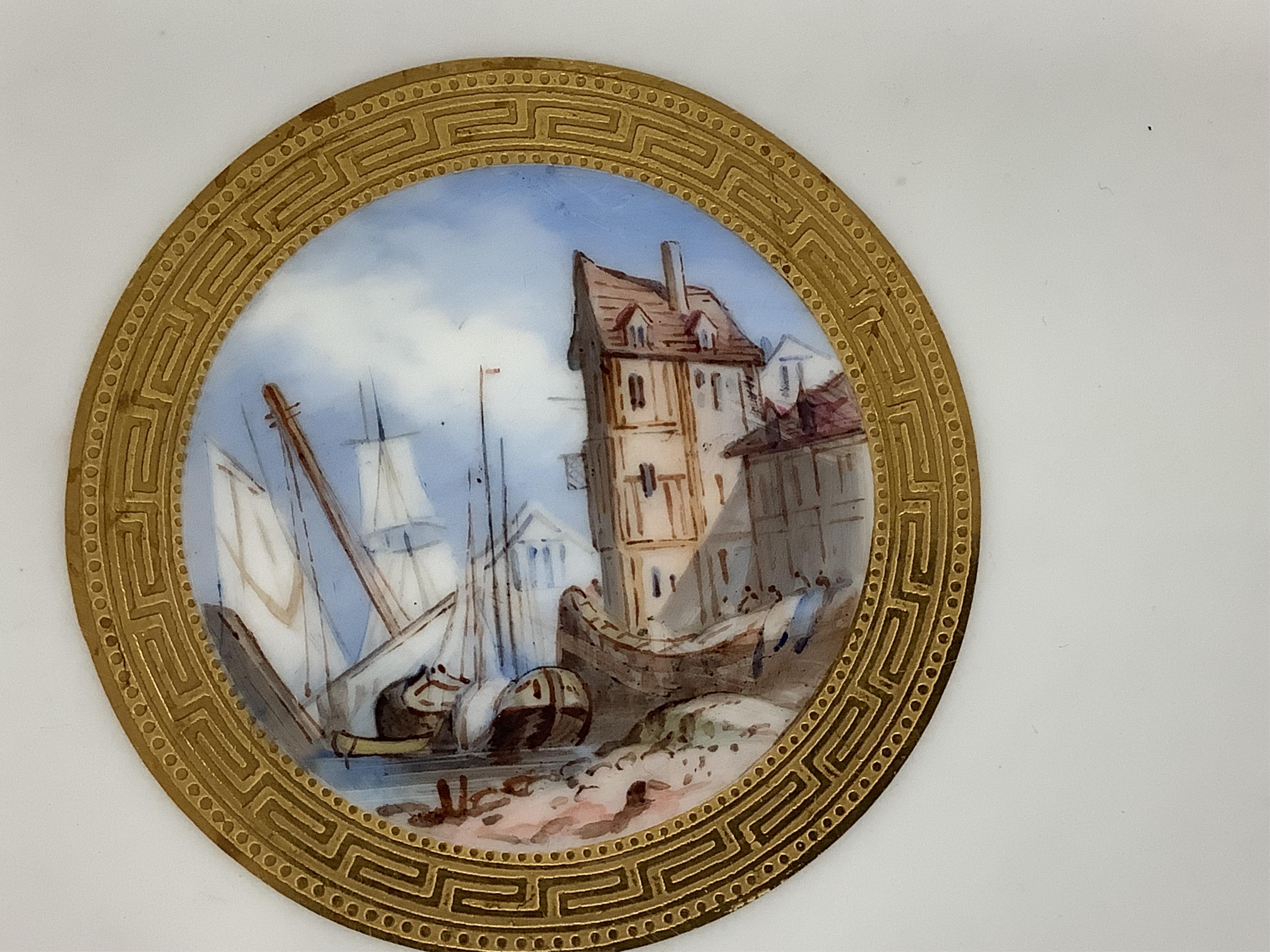 A Minton turquoise and gilt cabinet plate, decorated with butterflies and central continental harbour scene, 24cm diameter.